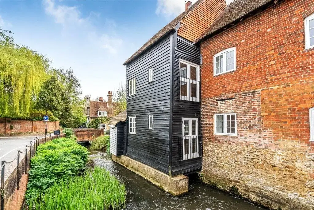 The Old Mill in Surrey, a Grade II listed mill beside the river, after its conversion to flats