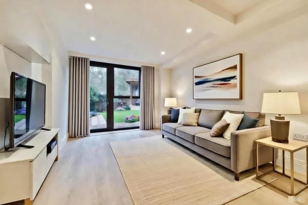Living room with a beige sofa and glass doors to a garden