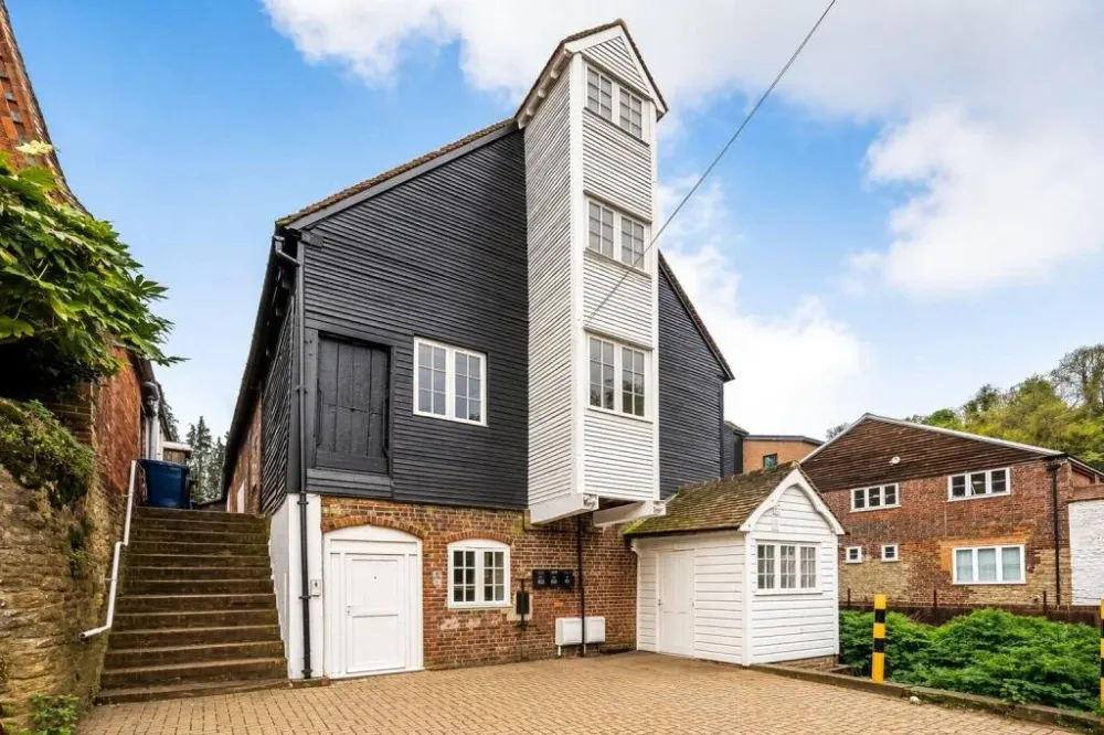 The mill’s weatherboarded exterior and brick base, with steps up the side