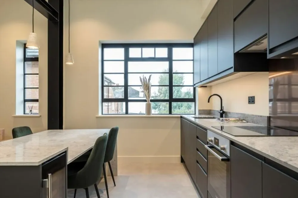 Kitchen with black-framed factory windows and a small dining table