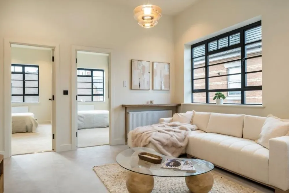 Living area with a factory-style window and a cream sofa
