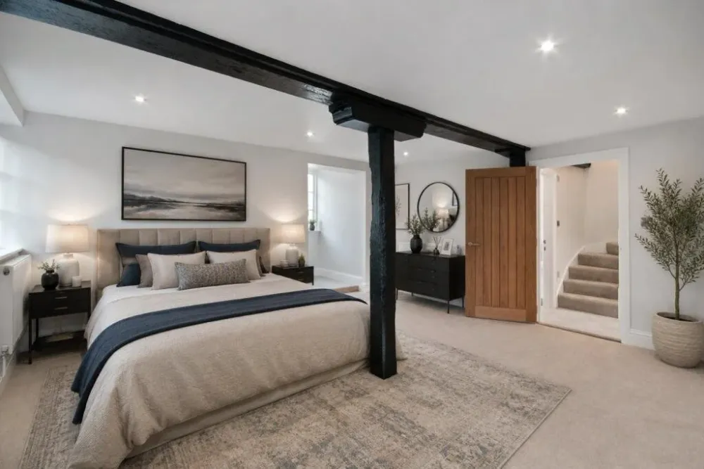 Bedroom with a black timber post and beam retained from the mill