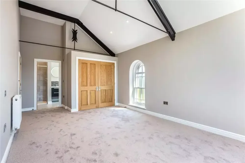 Bedroom with a sloping ceiling and timber doors