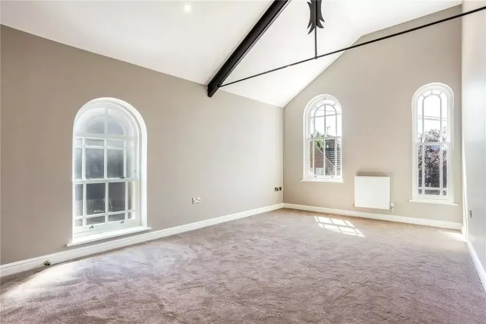 Bedroom lit by three arched windows
