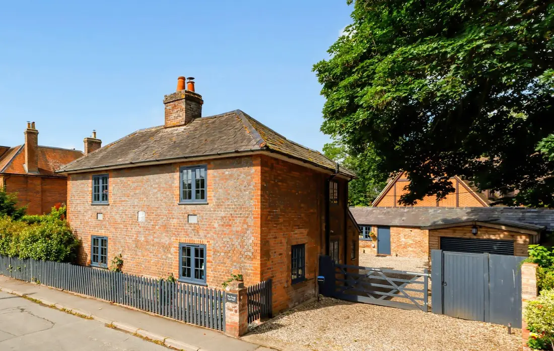 The Forge: a red-brick Georgian house with tall chimneys behind a picket fence