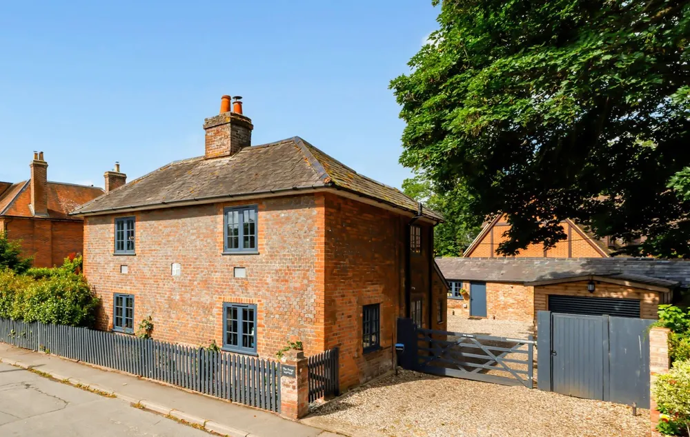 The Forge from the lane: a red-brick Georgian house with tall chimneys and white-framed windows