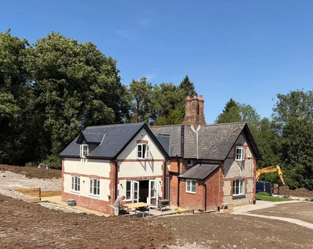The extended lodge in brick and flint, with the garden being laid out around it