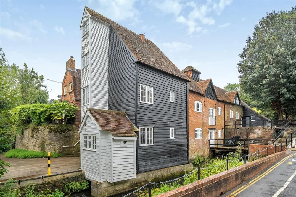 The white weatherboarded gable and the brick range of the converted mill