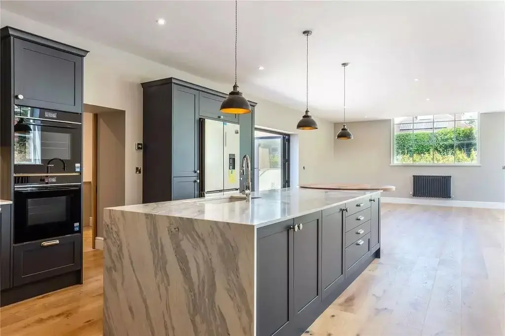 A finished kitchen in the converted Methodist Chapel: dark units, a marble-topped island and oak floors
