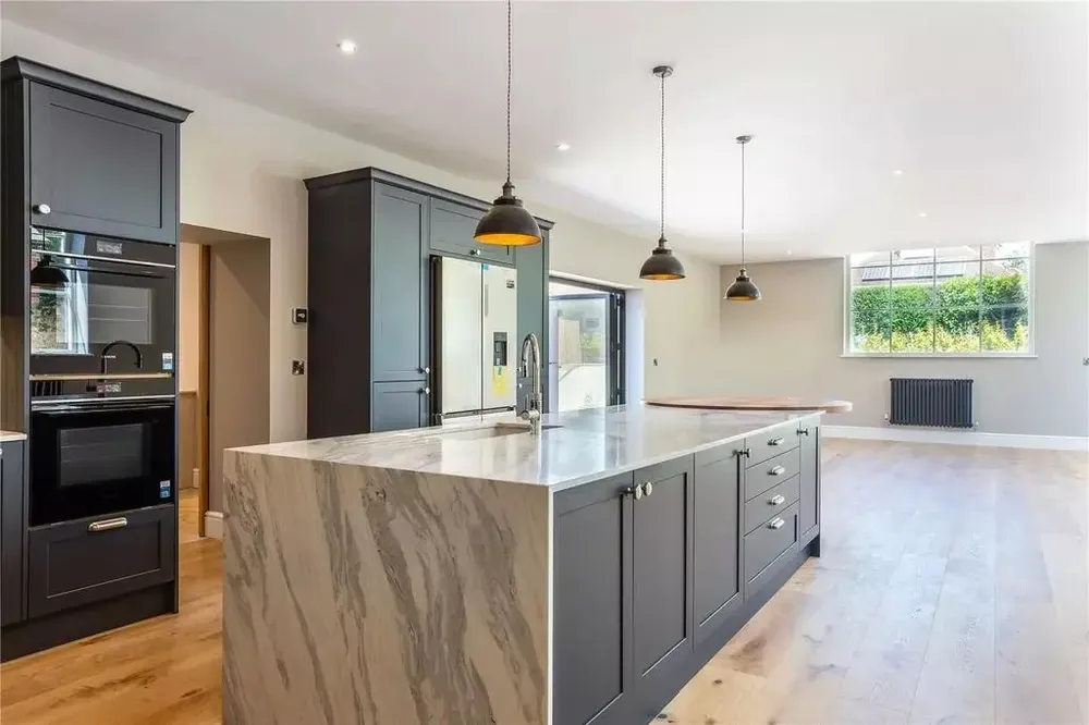 Kitchen in the converted Methodist Chapel, with a marble-topped island and dark units