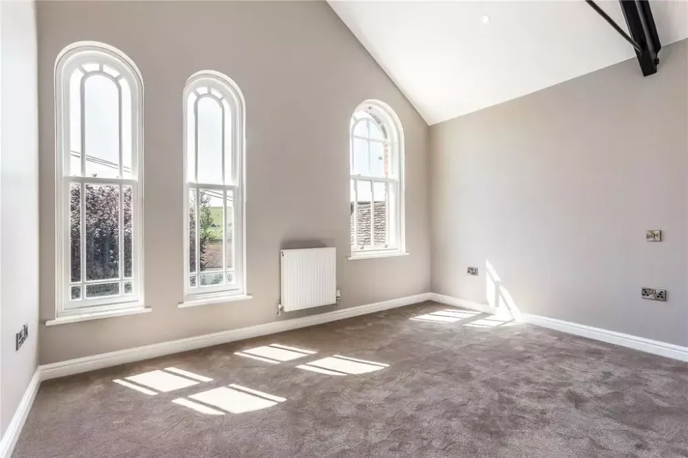 Main bedroom under the chapel’s tall arched windows