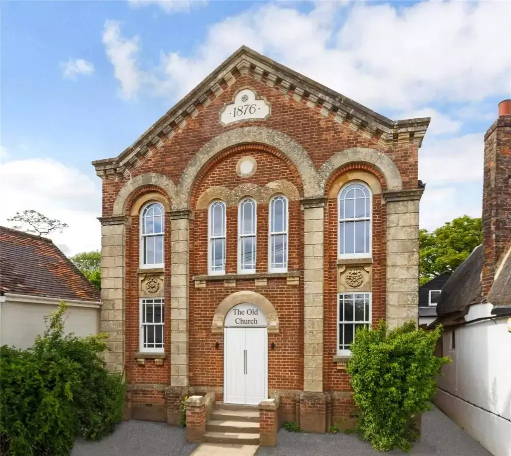The red-brick chapel facade, dated 1876, with arched windows and stone details