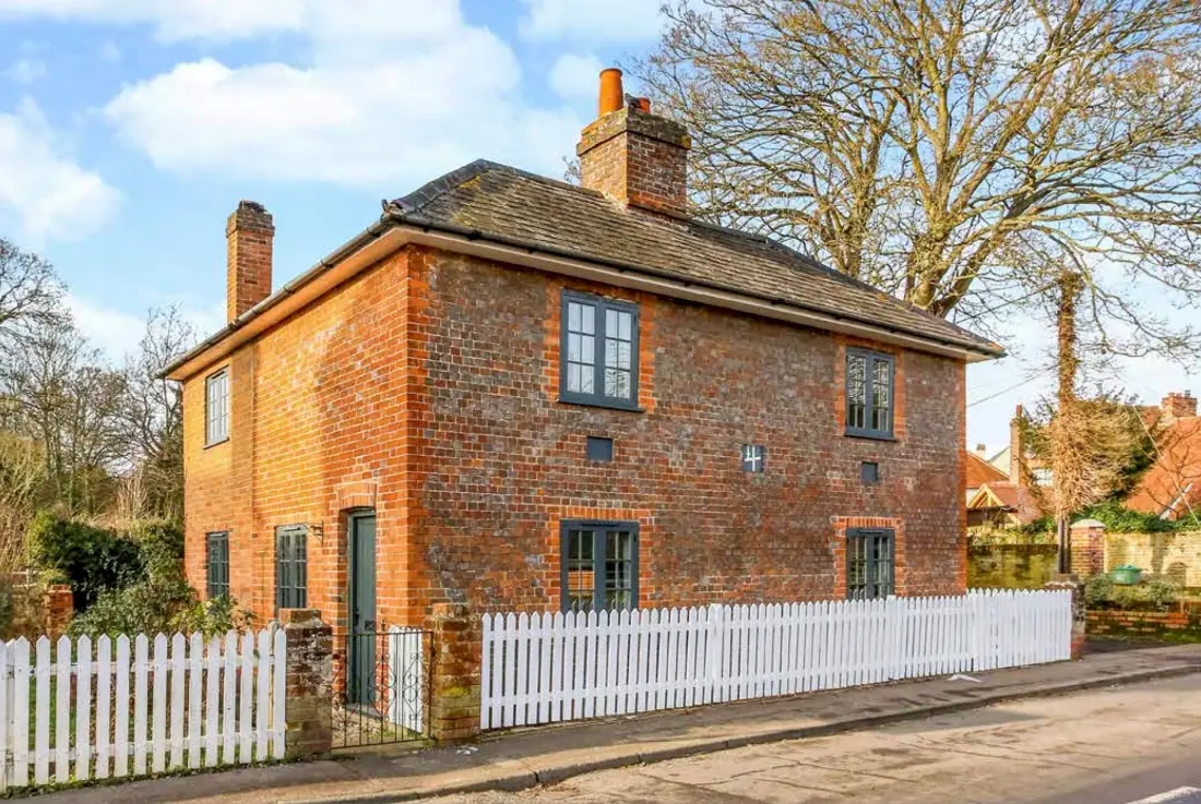 The Forge, a red-brick period house in Berkshire with tall chimneys and a white picket fence