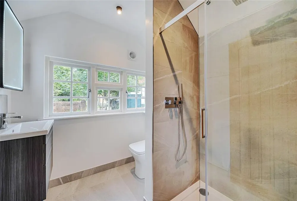 A shower room with a walk-in shower and a window over the mill