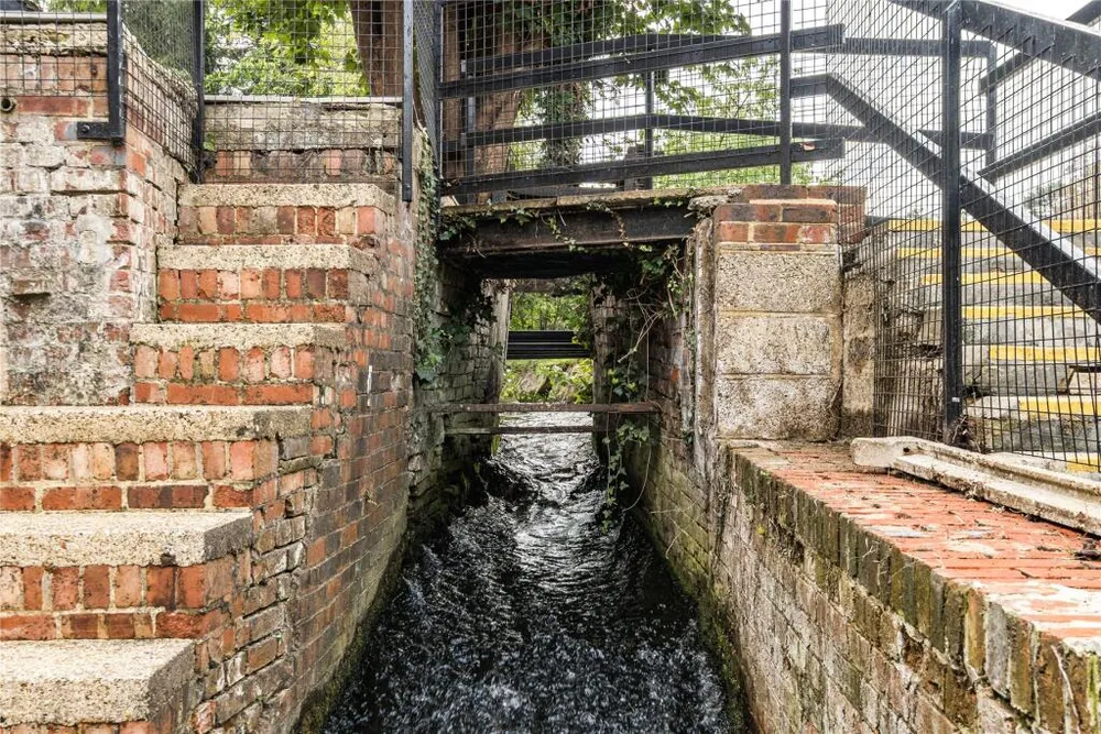 The brick sluice channel under the mill, with its iron railings