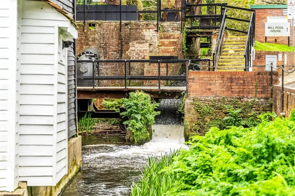 Water rushing through the old wheel race below the mill